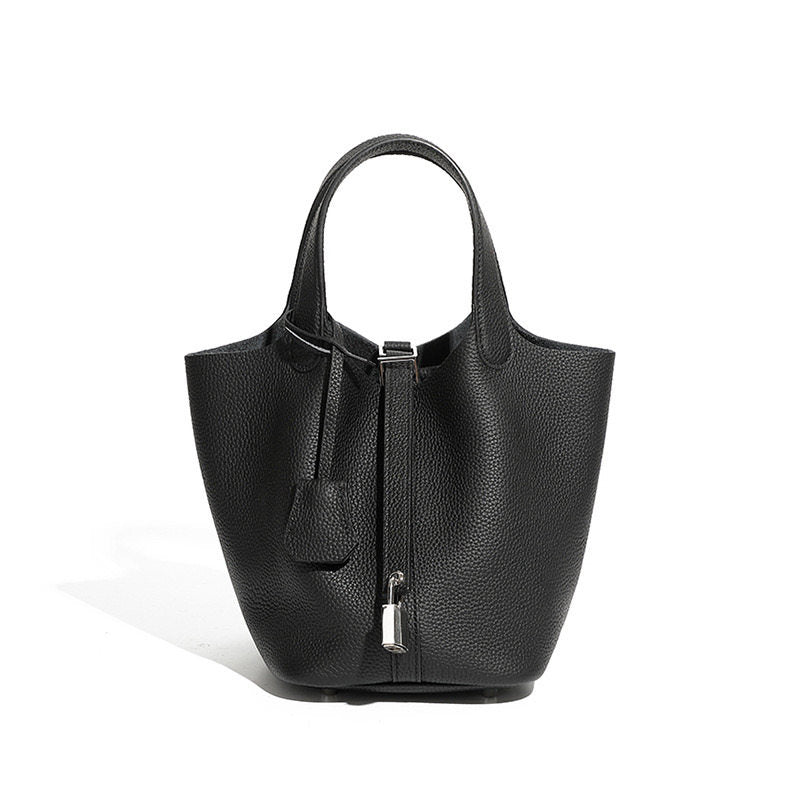 Leather bucket tote bag carried outdoors in a street setting