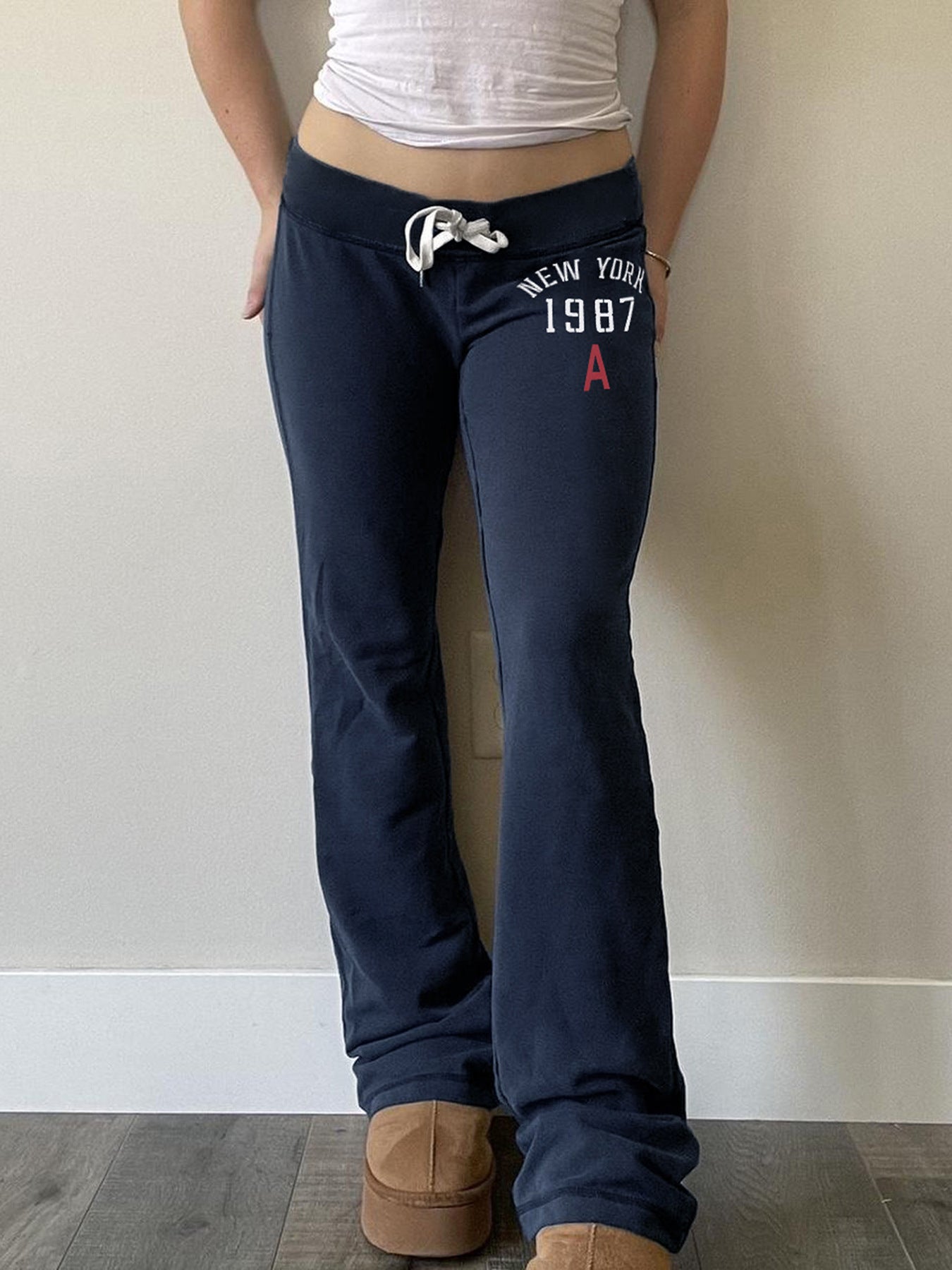 Navy low-rise flared drawstring sweatpants with New York 1987 print worn side back view