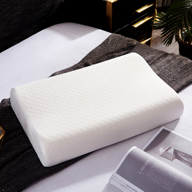 White knitted cover contour latex pillow resting on a made bed
