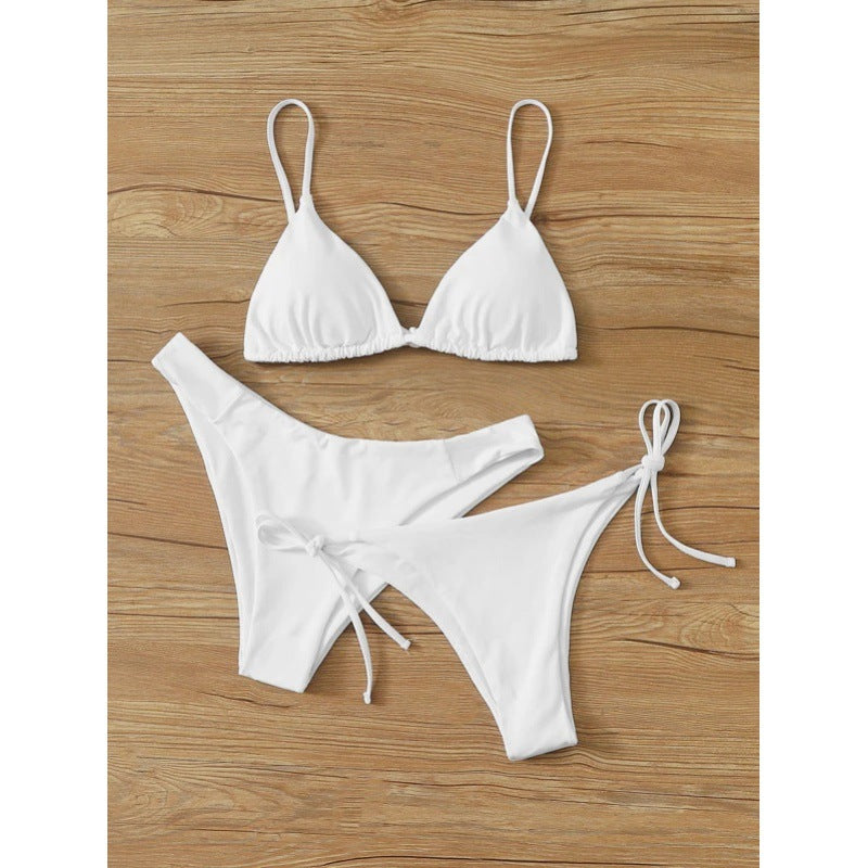 Solid color three-piece bikini set laid out on a clean studio background