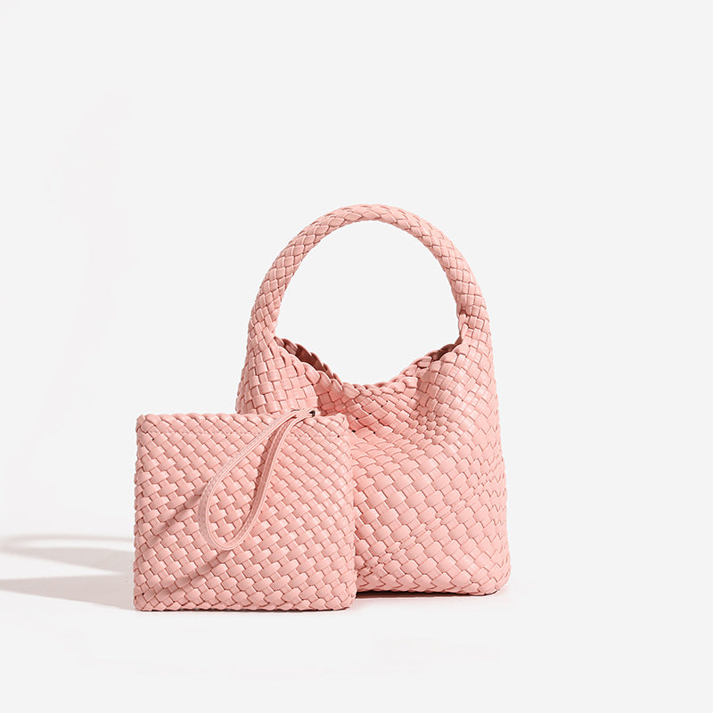Pink woven PU leather bucket bag and matching pink woven zip pouch on a pale studio background