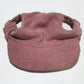 Small dog wearing the corduroy baseball cap with the brim at the front
