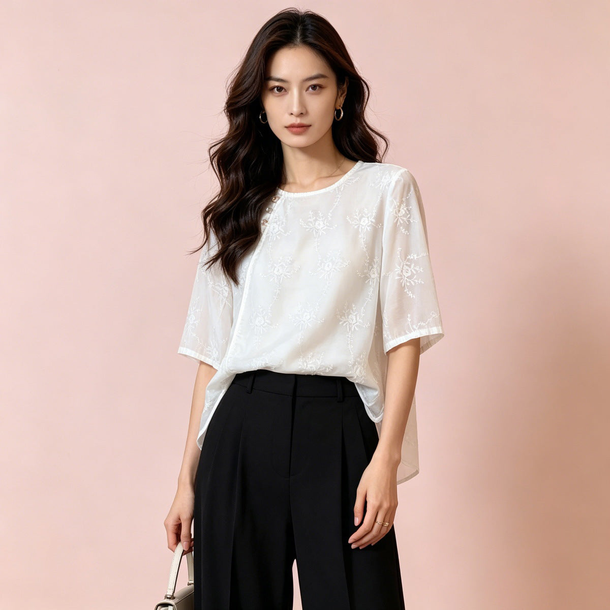 Loose ivory floral shirt with black wide leg pants and shoulder bag