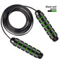 Black and green skipping rope laid flat on white with the coated steel cable coiled