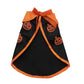Small white dog wearing a black pumpkin print Halloween cape and a bell topped witch hat