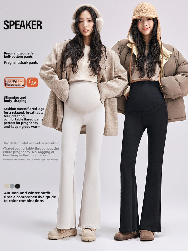 Two pregnant models in beige and black maternity bell-bottom pants with coats and winter boots