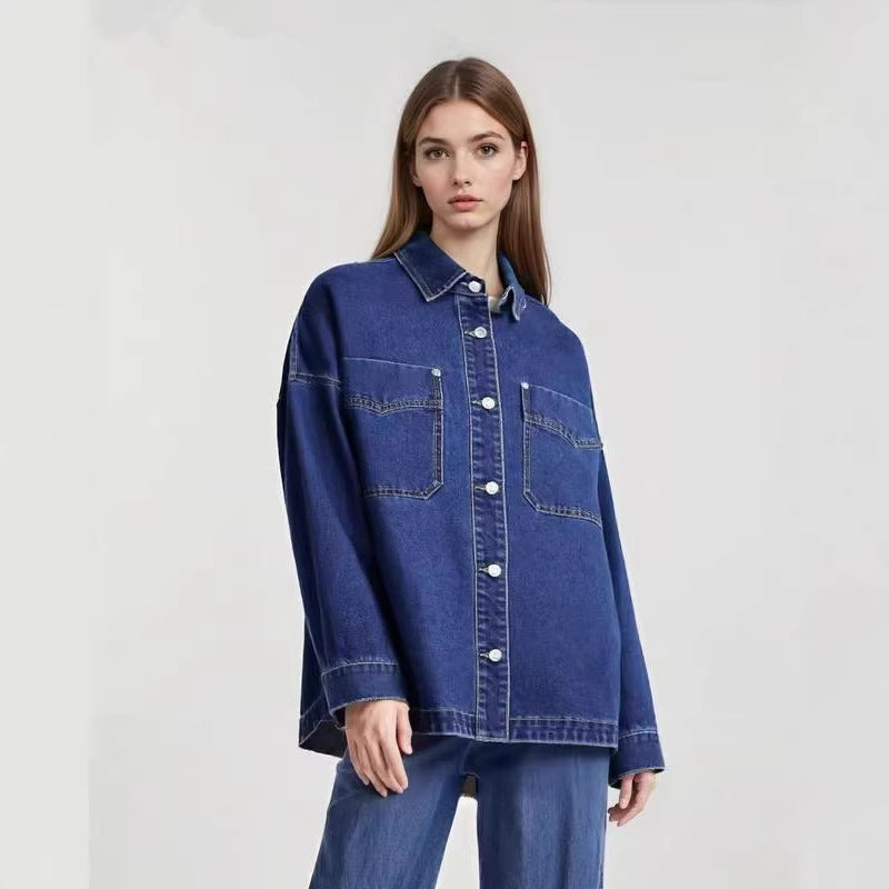 Woman wearing a dark blue washed denim shirt buttoned with two chest pockets and long sleeves over jeans