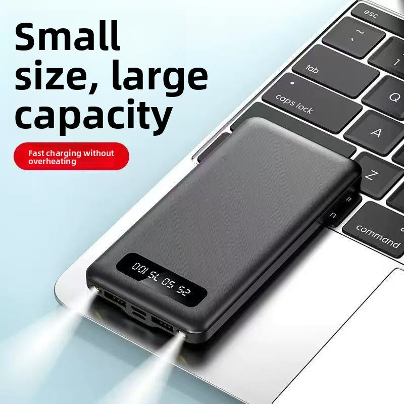 Black power bank with a digital display resting on a laptop keyboard, with the caption small size, large capacity