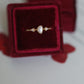 Dainty opal ring set inside a deep red velvet ring box, top view