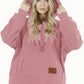 Pink sherpa fleece pet pouch hoodie on a woman with the hood pulled up over long hair