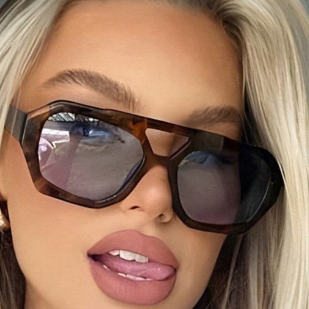 Polygonal contrast colour sunglasses worn for a bright day outdoors