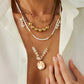 Gold layered necklace with chunky beads and a round coin pendant worn open