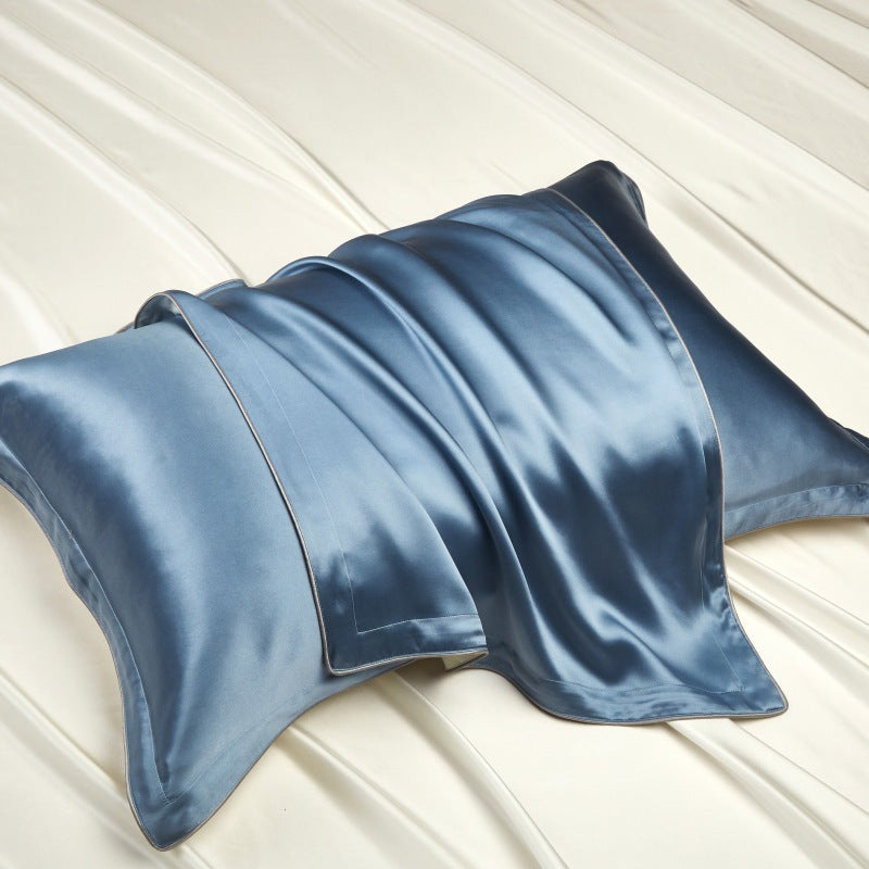 Mulberry silk pillowcase with a soft sheen and piped edge on a bed