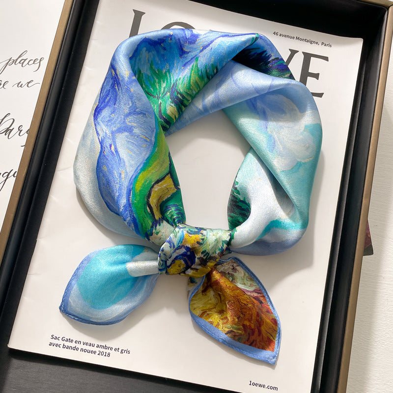 Blue and green abstract printed square scarf with a satin sheen and hemmed edges, shown displayed