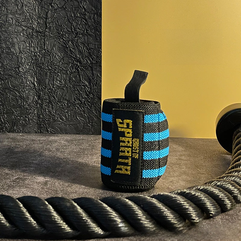 Black and blue elastic wrist wrap rolled up beside a heavy black training rope