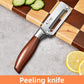 Vegetable peeler with a natural wood handle resting on a surface