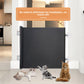 Black roll up pet gate on adhesive mounts across a kitchen doorway with three cats in front of it