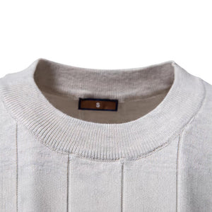 Side view of the cotton knit top showing the short ribbed sleeve and crew neck