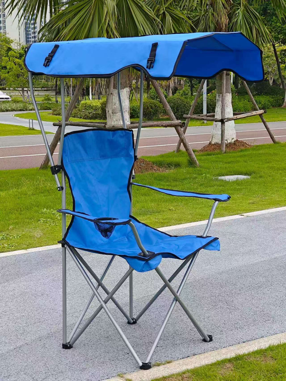 Blue foldable camping chair with a blue canopy, armrests and a cup holder, three-quarter view