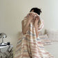 Reference view of the plush pile and printed stripe on the throw blanket