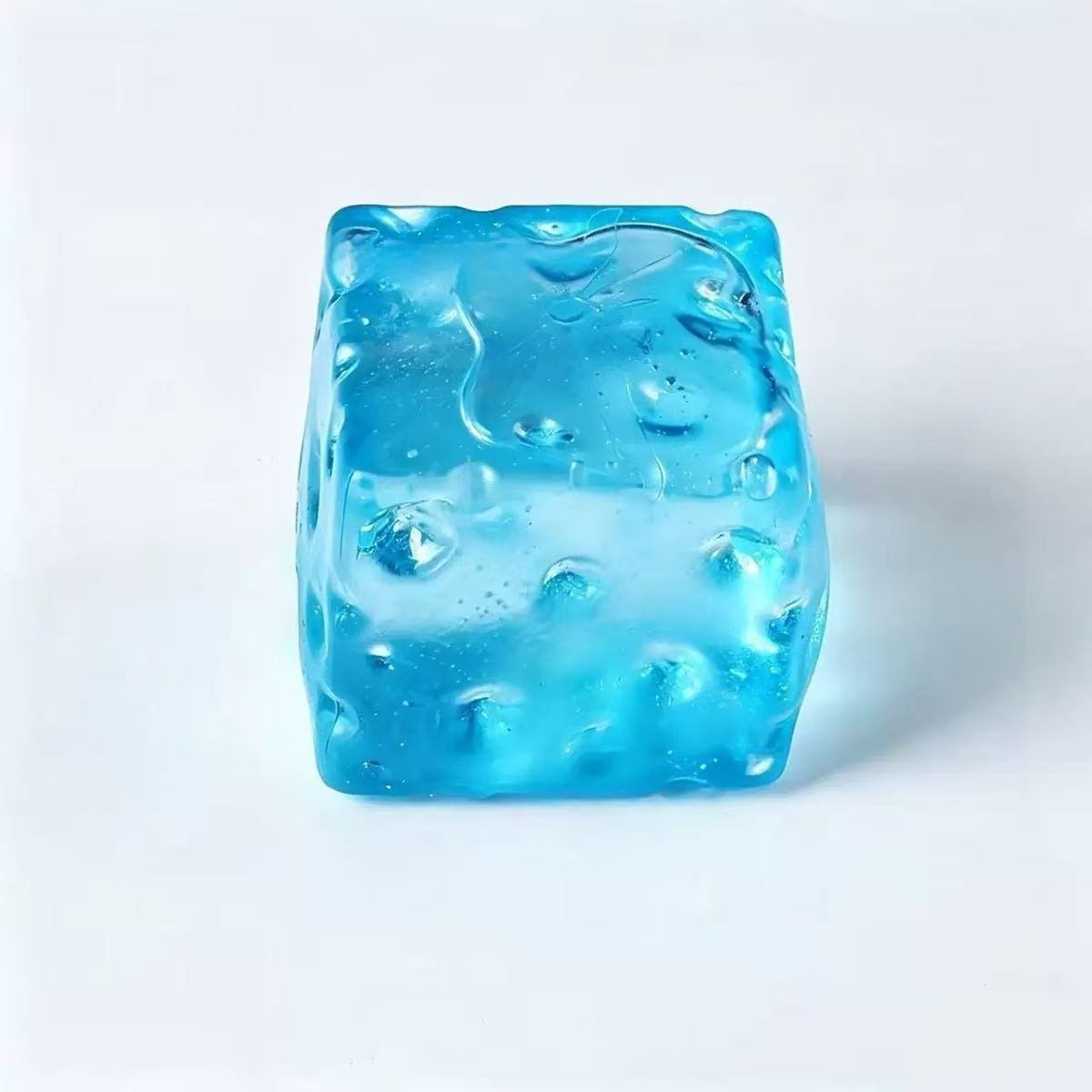 Translucent blue cheese cube squishy toy with moulded holes