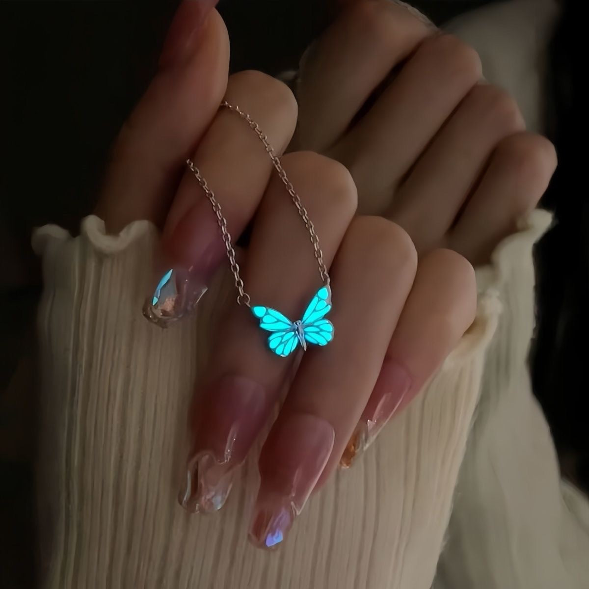 Butterfly bracelet with blue enamel charms on a silver tone chain on a wrist
