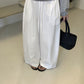 Front view of white barrel leg cotton trousers styled with a striped top