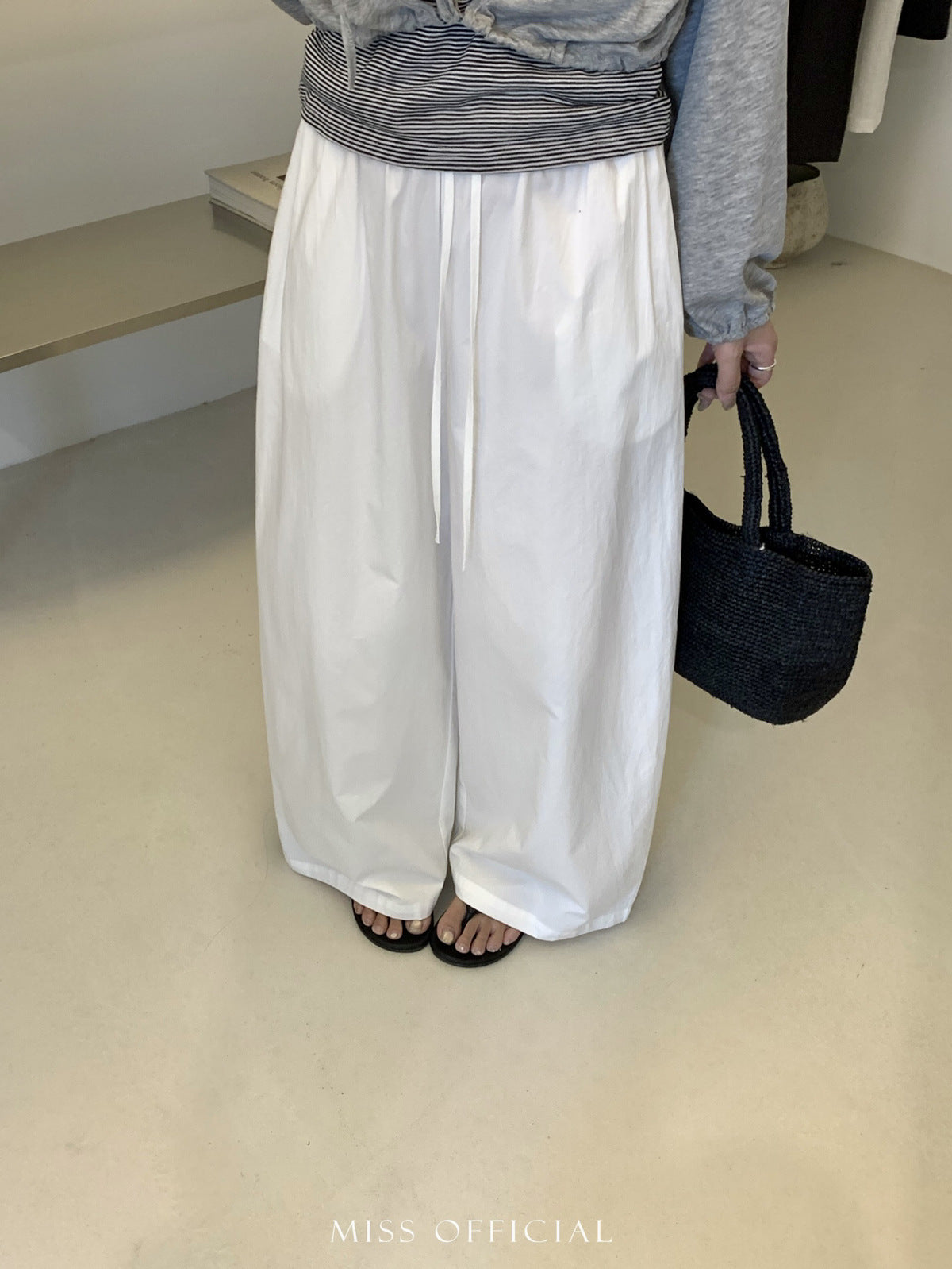 Front view of white barrel leg cotton trousers styled with a striped top