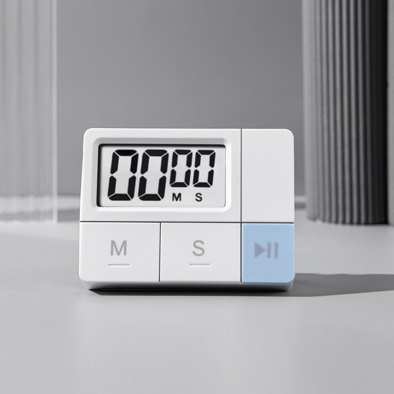 White digital kitchen timer with large LCD and three control buttons on a grey surface