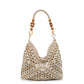 Off-white open-weave hobo bag with a light cord and wooden bead handle on a plain white studio background