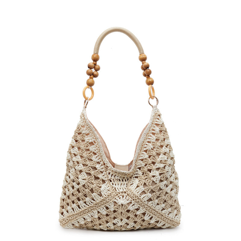 Off-white open-weave hobo bag with a light cord and wooden bead handle on a plain white studio background