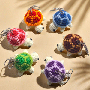 Six crochet turtle keychains in green purple orange blue brown and pink, top view