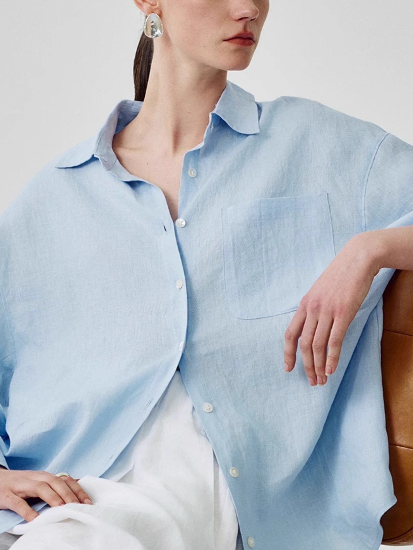 Linen shirt shown half tucked with the sleeves pushed to the elbow