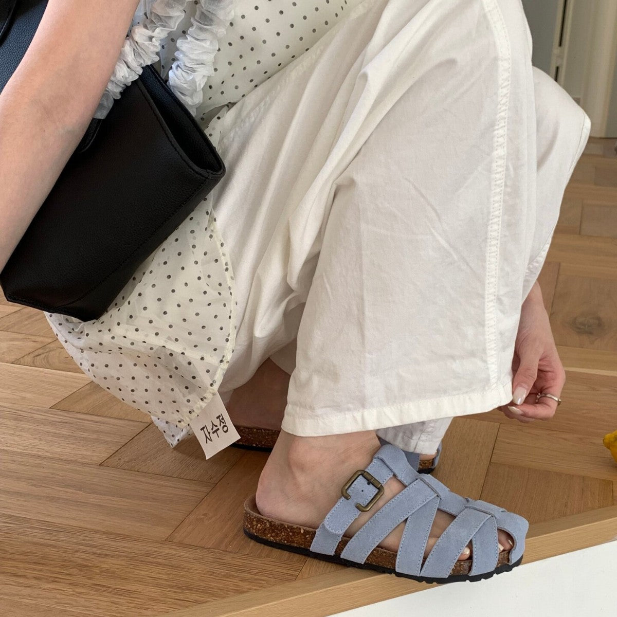 Pastel woven slide sandals worn in a daily indoor scene