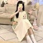 Woman taking a phone selfie in a cream nightgown with green short sleeves and a carrot rabbit print on the front, view 3 of 7