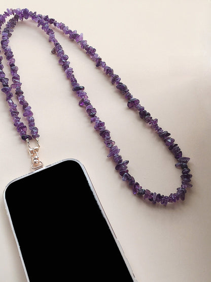 Purple chip-bead phone strap worn cross-body over a shoulder with a clip end
