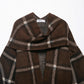 Close-up of the draped scarf collar and BBWM WOMAN neck label on the brown plaid knit cardigan