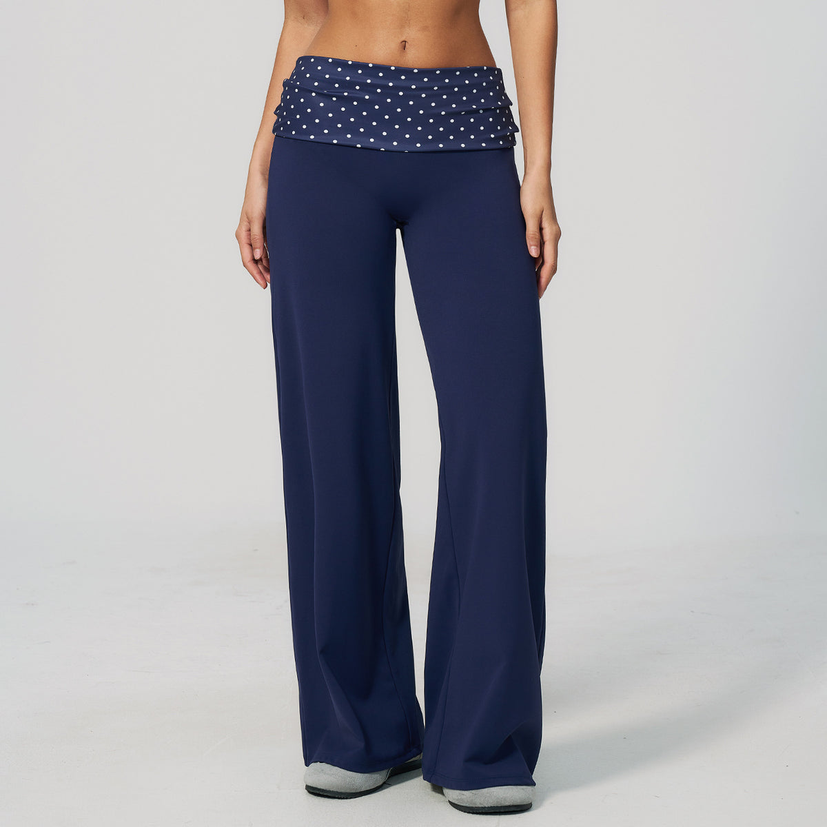 Model in wide leg pants with a fold over printed waistband, navy with white polka dots