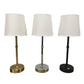 Gold, silver and black metal table lamps with white fabric shades on a white background
