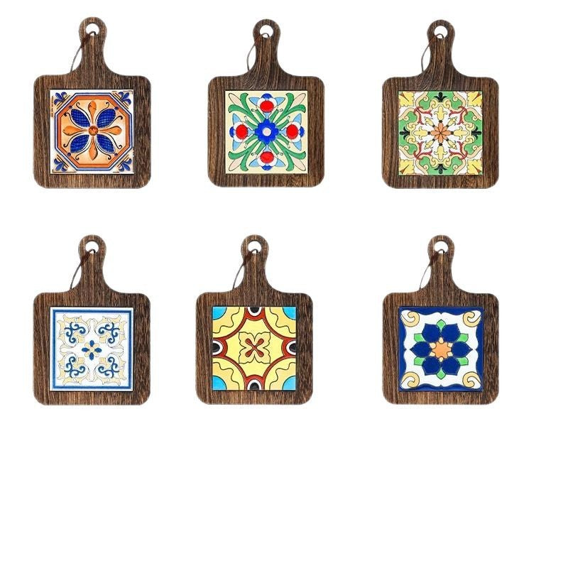 Six ceramic tile wood trivets with different painted patterns on a white background