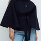 Short cape jacket with cape cut sleeves and a matching self tie belt at the waist