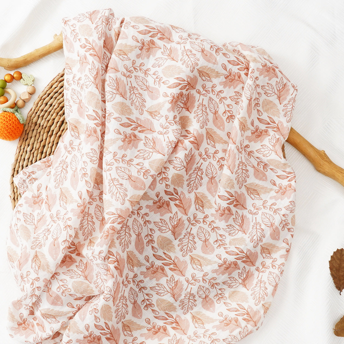 Large cotton muslin gauze baby blanket laid out, showing the loose breathable weave and print
