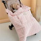 Caregiver pushing a stroller with the quilted cape covering the baby