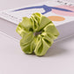 Satin scrunchie wrapped around a wrist as an accessory