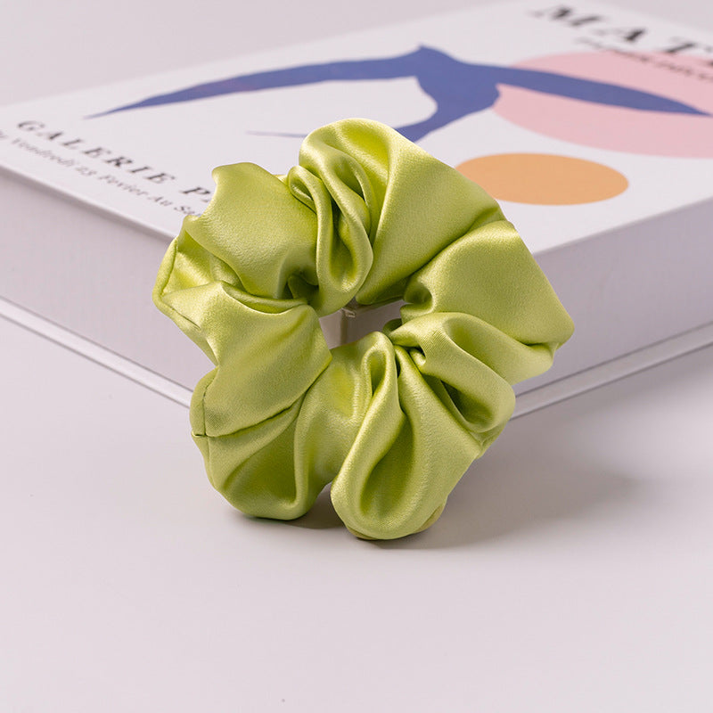 Satin scrunchie wrapped around a wrist as an accessory