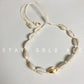 Gold accent version of the cowrie shell choker, one gold tone shell at the centre of the row