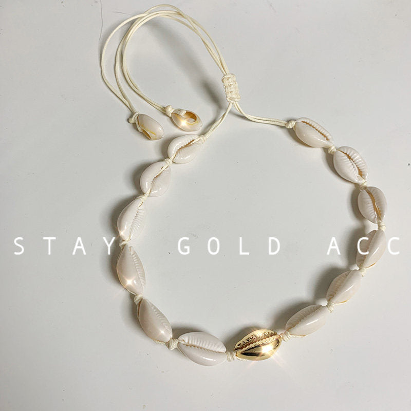 Gold accent version of the cowrie shell choker, one gold tone shell at the centre of the row