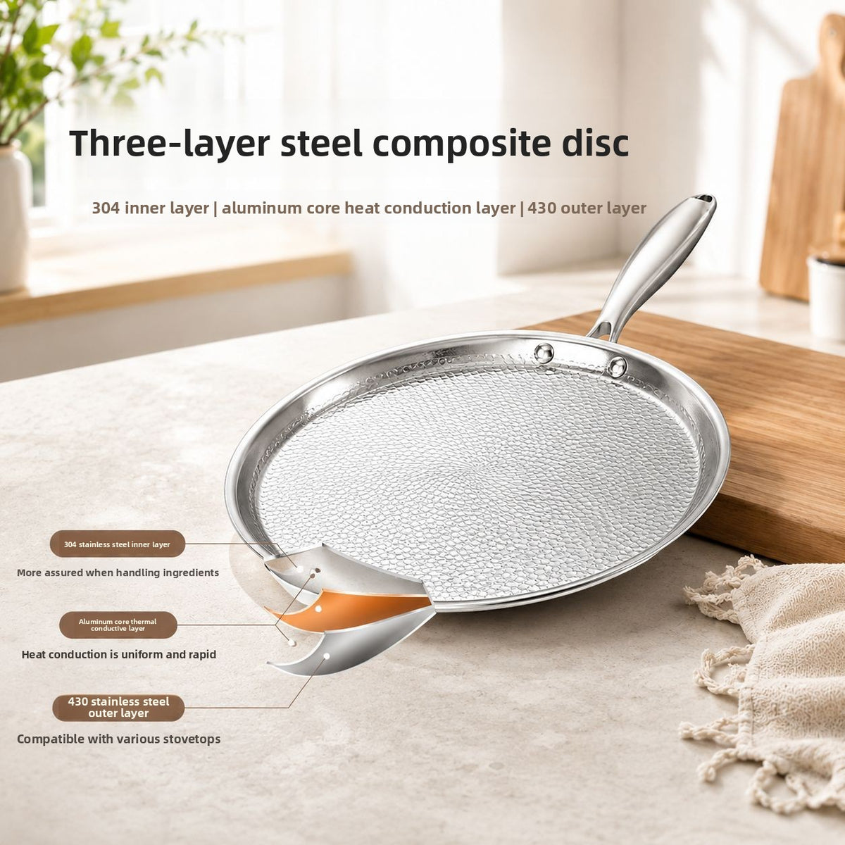 Hammered flat pan on a wooden counter with a cutaway of its three-layer composite base, 30 cm option