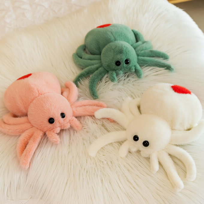Emerald green reversible spider plush with a red heart on its back and bead eyes