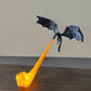 Black resin dragon figurine held above a lit orange flame stand against a plain wall